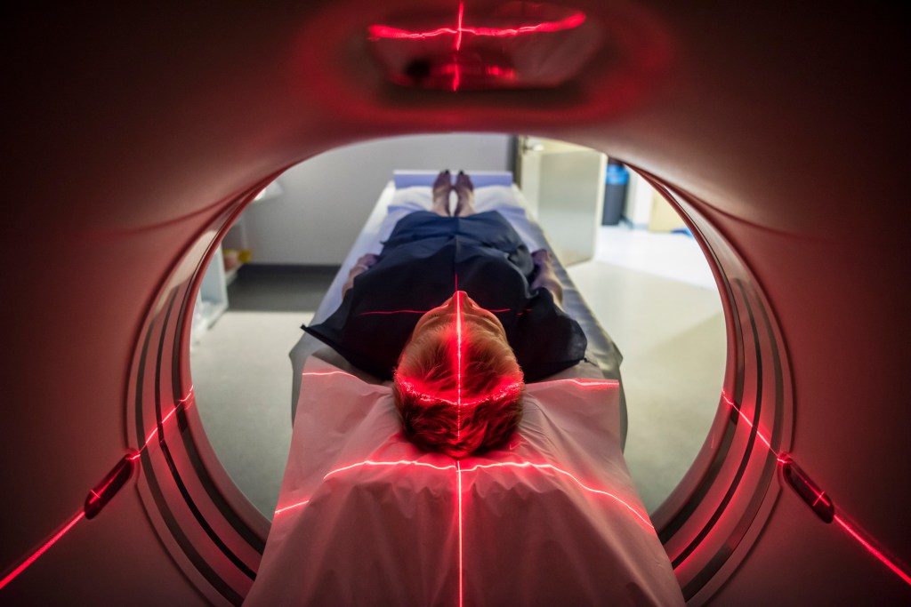 Person undergoing a Cat scan in hospital with PET scanning equipment