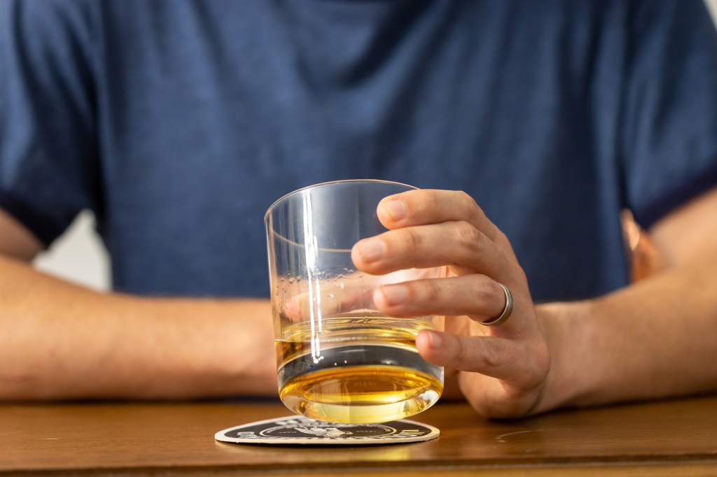 The man sitting in a bar, enjoying a glass of whiskey