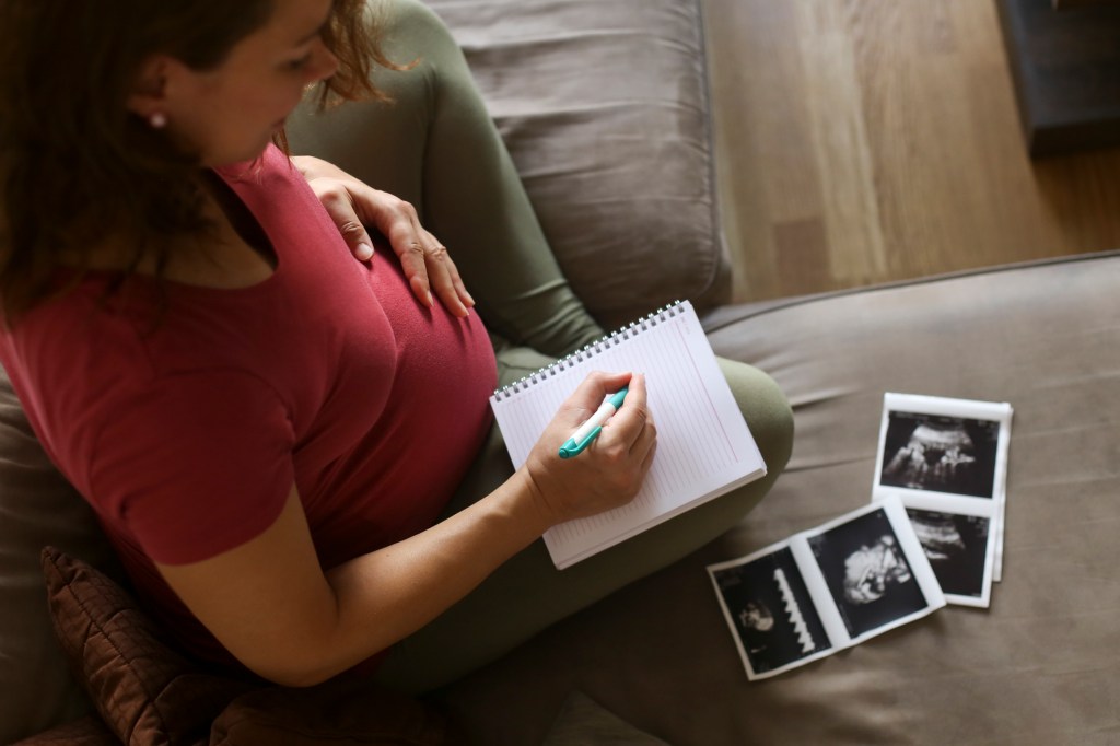 Woman who thinks about the names of the pregnant baby with ultrasound photographs
