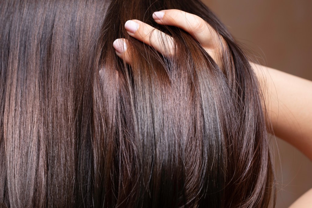Closing a beautiful brunette woman who shakes her shiny hair run