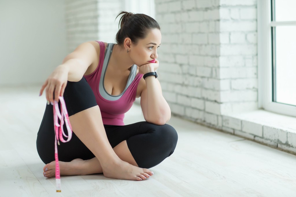 woman sitting with the band of exercises that seemed sad by the window